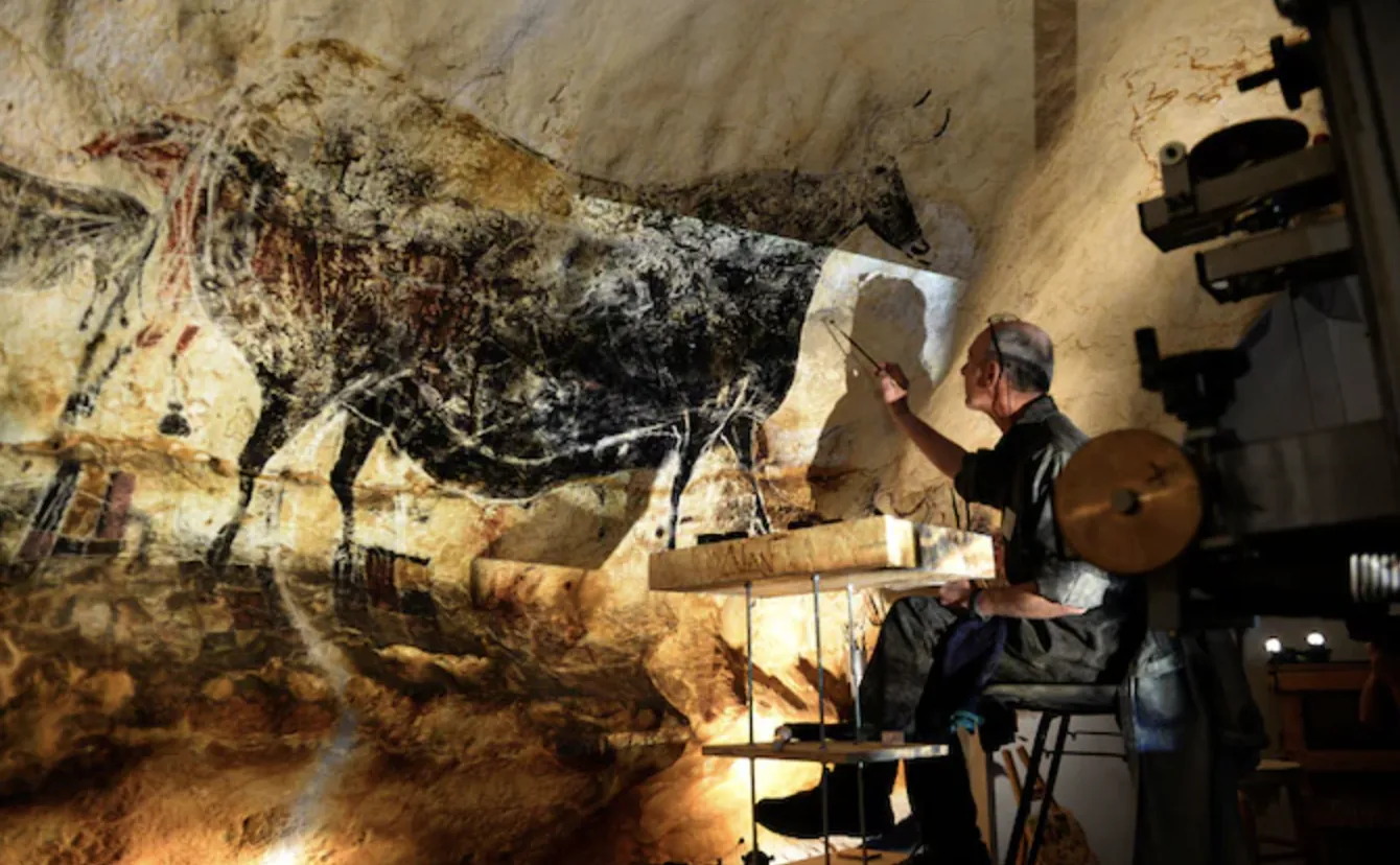 An artist recreating a Lascaux bull painting
