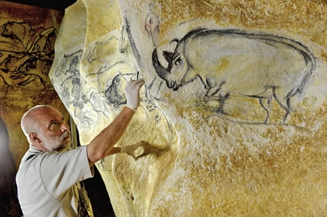 An artist recreating the Chauvet rhinoceros drawing